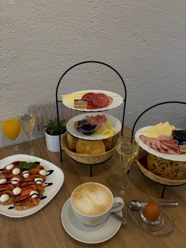 verschiedene Frühstücksvariantionen, mit Wust und Käse auf Etageren und einer Tomaten-Mozzarella-Stulle dekoriert mit Balsamico-Crema