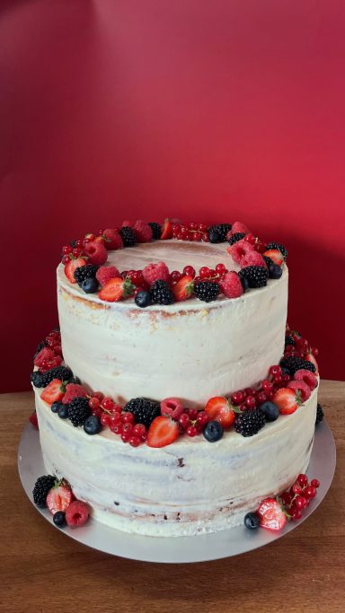 2-stöckige Hochzeitstorte- weiß eingestrichen und am Tortenrand und oben mit verschiedenen Beeren dekoriert