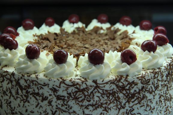 klassische Schwarzwälder-Kirschtorte mit handgemachten Schokoraspeln und Sauerkirschen als Dekoration