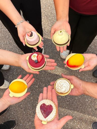 verschiedenste Törtchen werden auf Händen präsentiert und in einer Art Kreis gehalten.