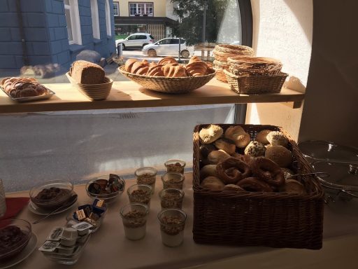 ausschnitt vom Frühstücksbuffet, verschiedene Brötchen, Croissants, Joghurt mit Granola